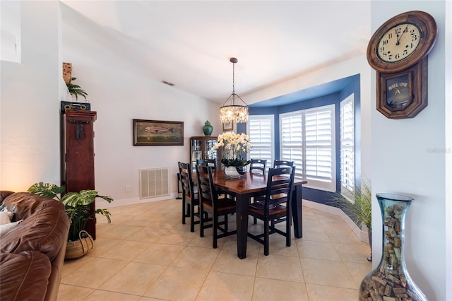 dining space featuring vaulted ceiling, an inviting chandelier, and light tile patterned floors