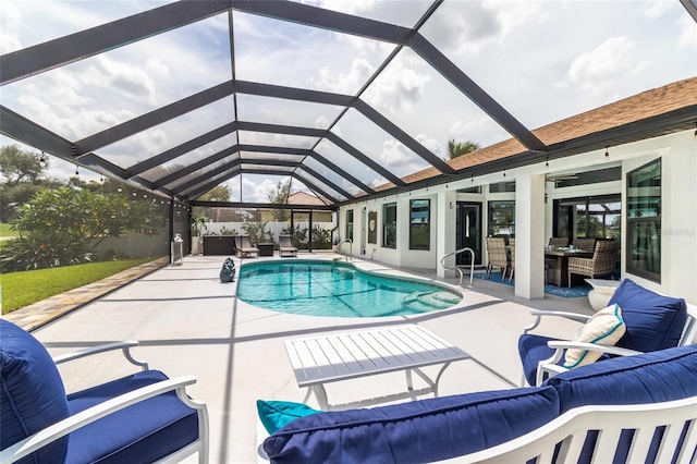 view of pool featuring an outdoor hangout area, glass enclosure, and a patio area