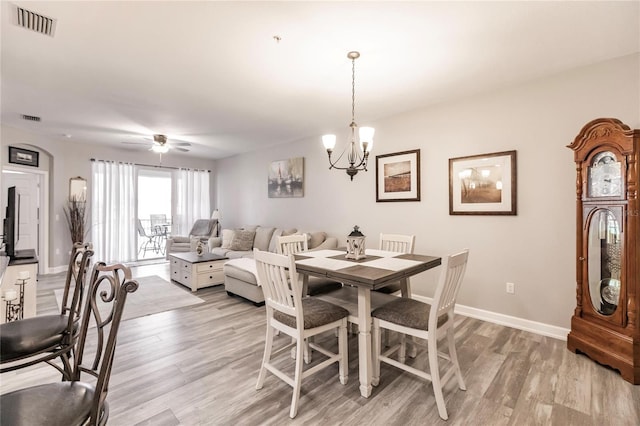 dining area featuring ceiling fan with notable chandelier and light hardwood / wood-style flooring