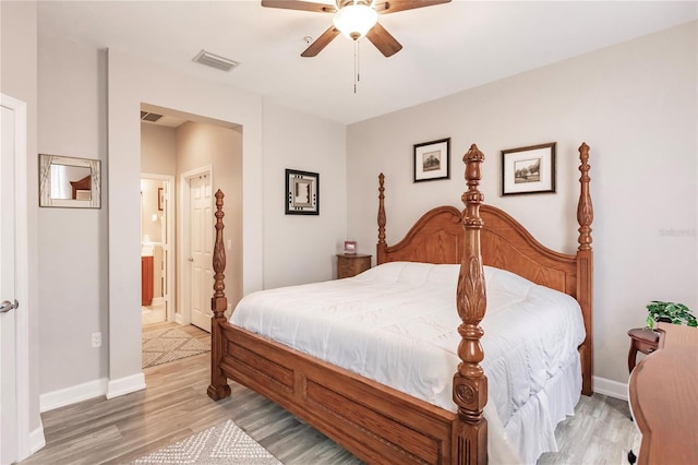 bedroom featuring ceiling fan, light wood-type flooring, and ensuite bath