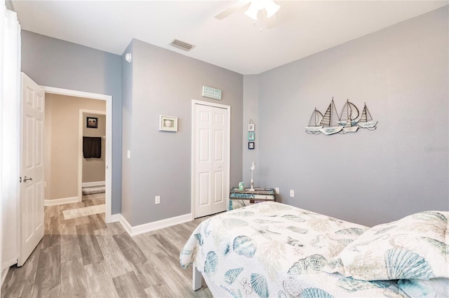 bedroom featuring light wood-type flooring, ceiling fan, and a closet