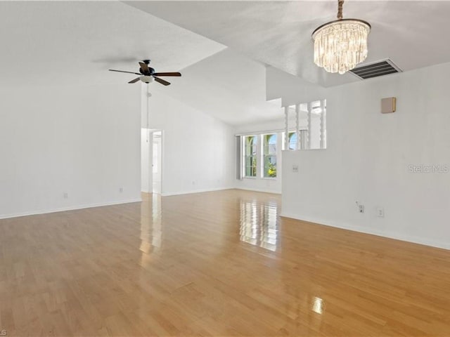 unfurnished living room with vaulted ceiling, light wood-type flooring, and ceiling fan with notable chandelier