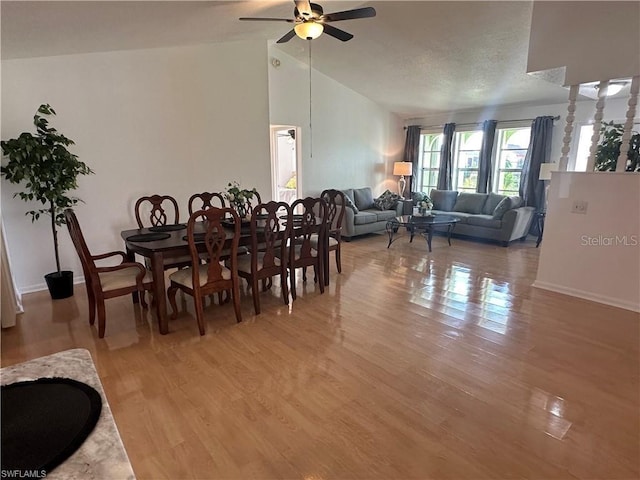 dining area featuring lofted ceiling, wood-type flooring, and ceiling fan