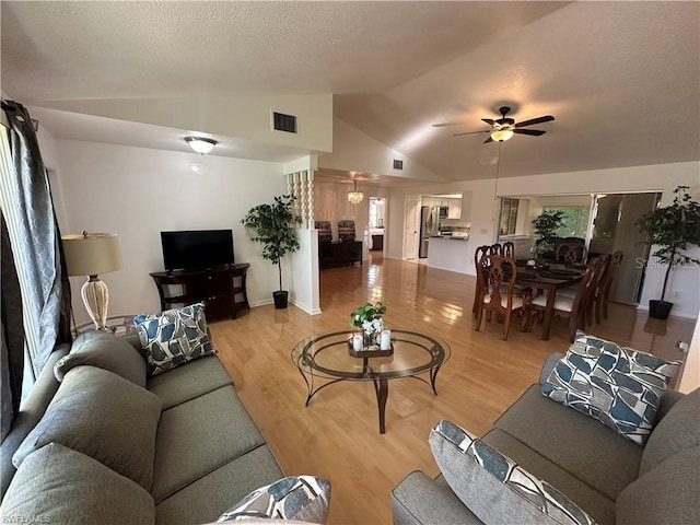 living room featuring vaulted ceiling, light wood-type flooring, and ceiling fan