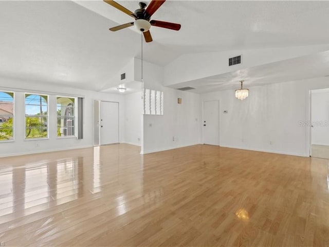 unfurnished living room with light hardwood / wood-style floors, ceiling fan with notable chandelier, and vaulted ceiling