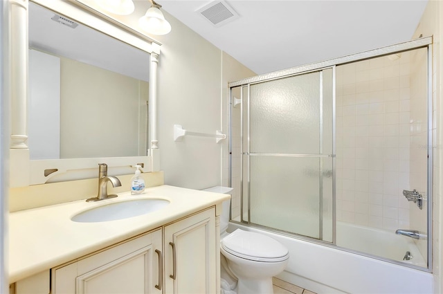 full bathroom featuring tile patterned floors, vanity, enclosed tub / shower combo, and toilet