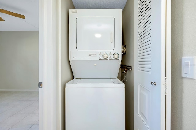 washroom with ceiling fan, stacked washing maching and dryer, and light tile patterned floors