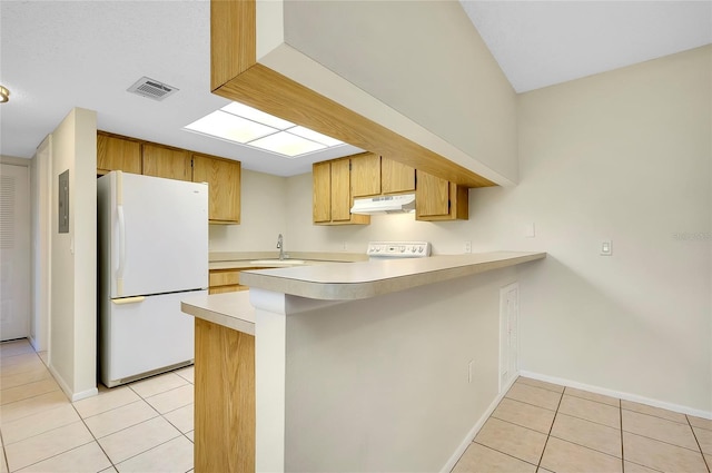 kitchen with kitchen peninsula, sink, light tile patterned floors, and white refrigerator