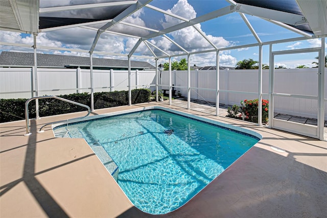 view of swimming pool with glass enclosure and a patio area