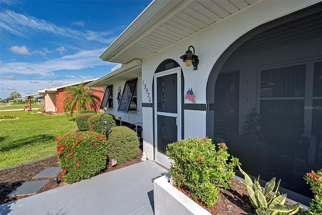 entrance to property featuring a lawn