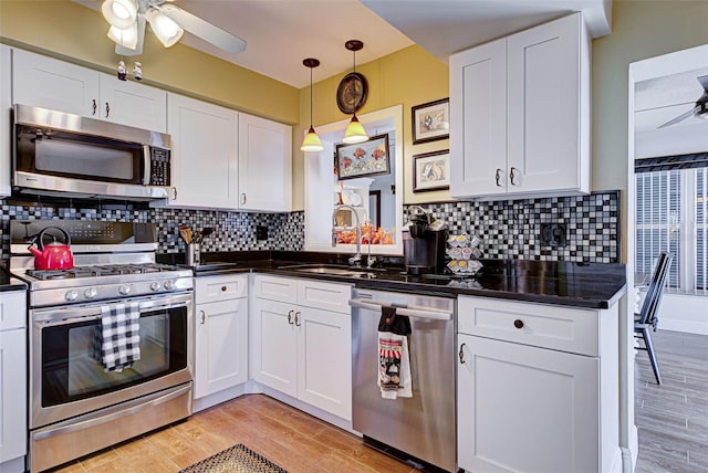 kitchen featuring light wood-type flooring, white cabinetry, and appliances with stainless steel finishes