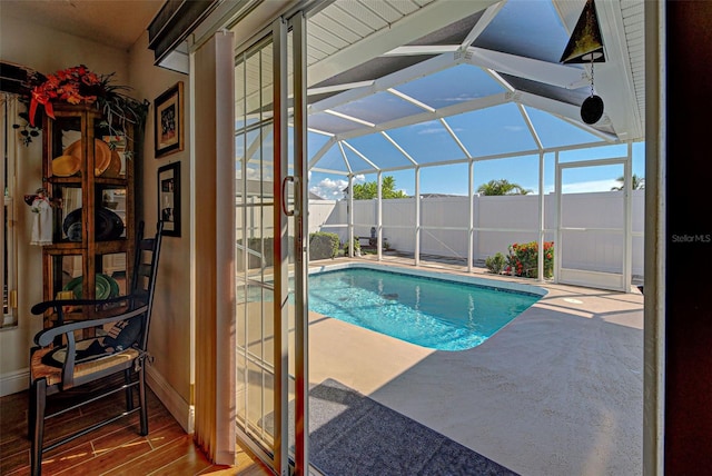 view of swimming pool featuring a patio and glass enclosure