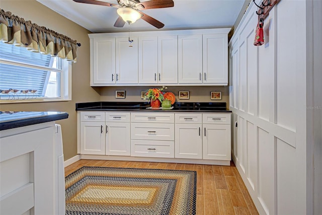 kitchen featuring light wood-type flooring, white cabinetry, and ceiling fan