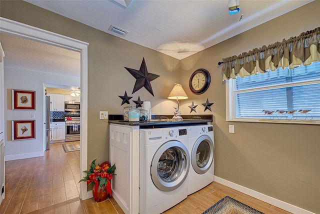 laundry area featuring light hardwood / wood-style flooring, ceiling fan, and separate washer and dryer