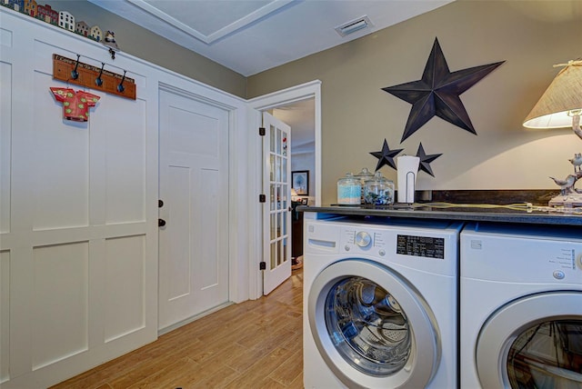 laundry room with separate washer and dryer and light hardwood / wood-style flooring