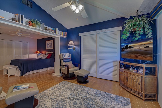 bedroom featuring ceiling fan, wood-type flooring, a textured ceiling, a closet, and vaulted ceiling