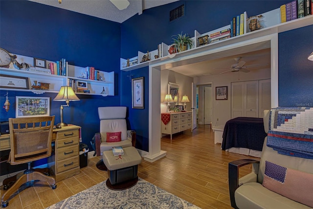 bedroom featuring ceiling fan, a textured ceiling, a closet, and hardwood / wood-style floors