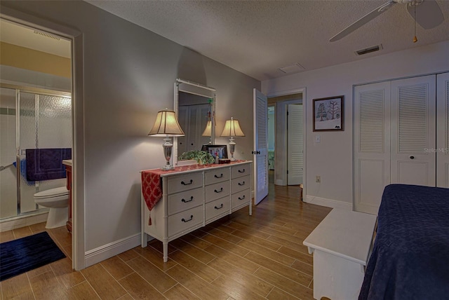 bedroom with light wood-type flooring, a closet, a textured ceiling, ensuite bathroom, and ceiling fan