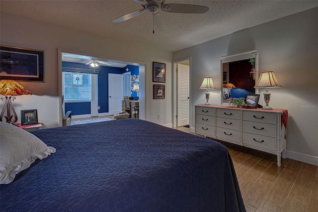 bedroom with a textured ceiling, ceiling fan, and hardwood / wood-style flooring