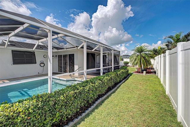 view of pool with a lanai, a patio area, and a yard