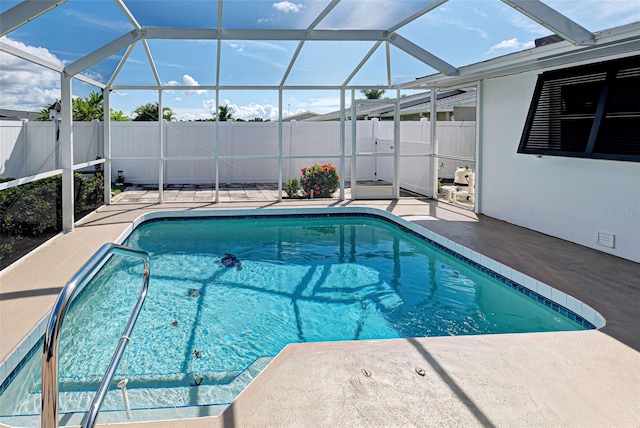 view of swimming pool featuring a lanai and a patio area