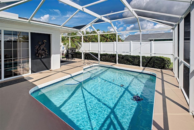 view of pool featuring glass enclosure and a patio