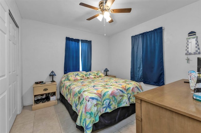 bedroom with a closet, light tile patterned flooring, and ceiling fan