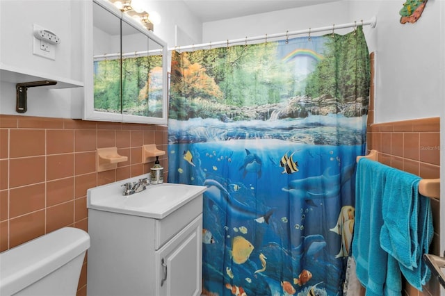 bathroom with tile walls, curtained shower, vanity, and toilet