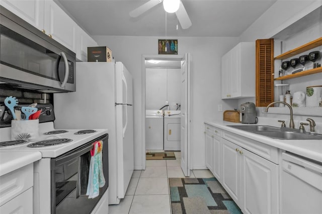 kitchen with independent washer and dryer, white cabinets, white appliances, light tile patterned floors, and sink