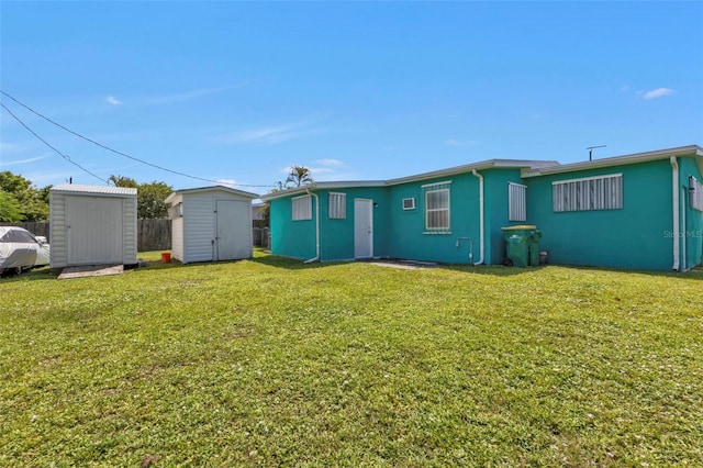 rear view of property featuring a storage shed and a lawn