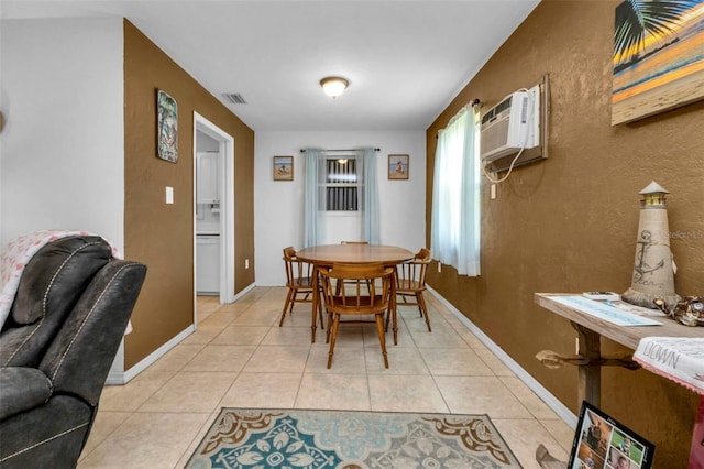 tiled dining room featuring a wall mounted AC