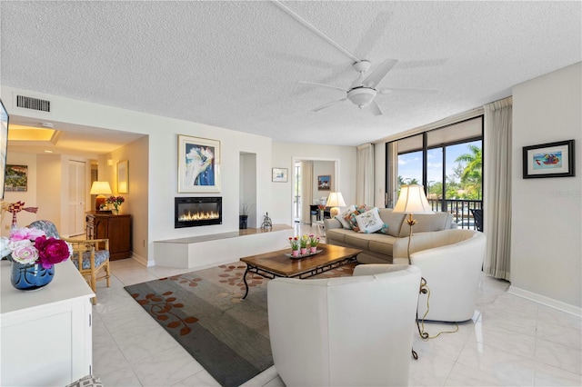 living room with a textured ceiling and ceiling fan