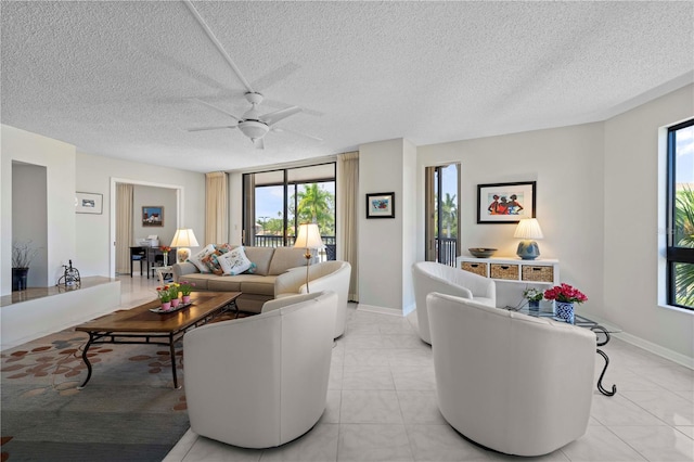 living room featuring ceiling fan, a textured ceiling, and light tile patterned floors