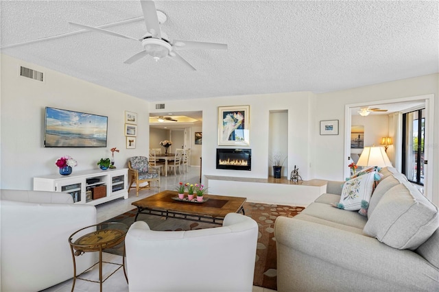 living room featuring a textured ceiling and ceiling fan