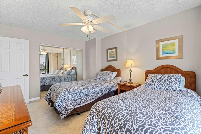 bedroom featuring light carpet, a closet, ceiling fan, and a textured ceiling