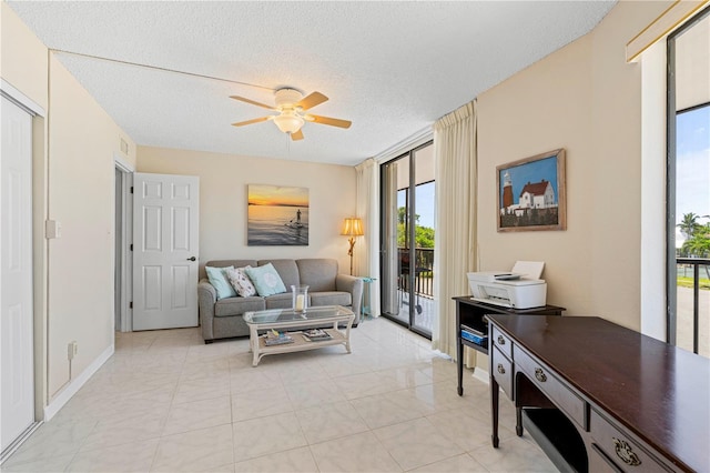 living room featuring ceiling fan and a textured ceiling