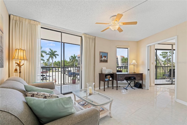 living room featuring ceiling fan and a textured ceiling