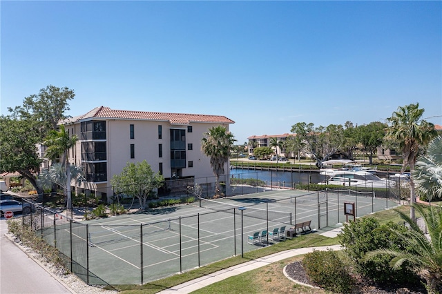 view of tennis court featuring a water view