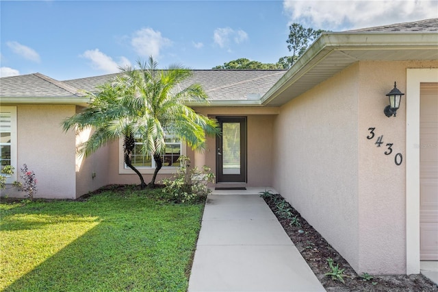 property entrance with a lawn