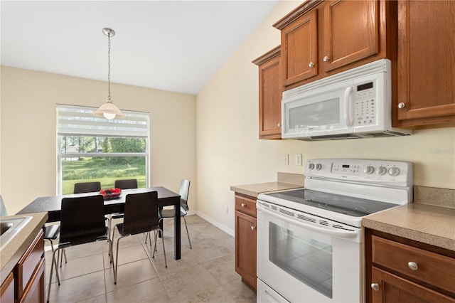 kitchen featuring decorative light fixtures, lofted ceiling, light tile patterned floors, and white appliances