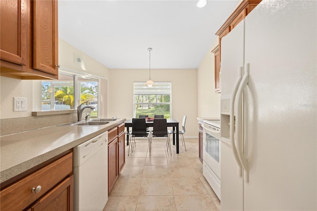 kitchen featuring light tile patterned floors, white appliances, sink, and decorative light fixtures