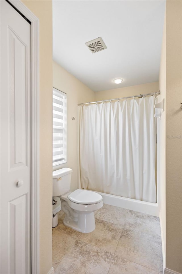 bathroom with walk in shower, tile patterned floors, and toilet