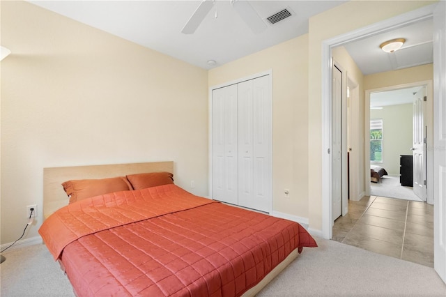 bedroom featuring a closet, light colored carpet, and ceiling fan