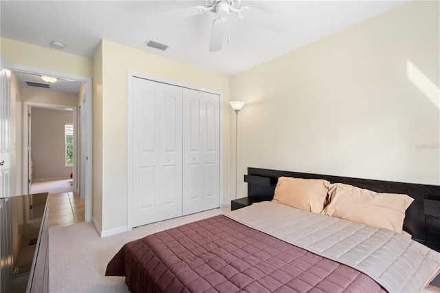 carpeted bedroom with ceiling fan and a closet