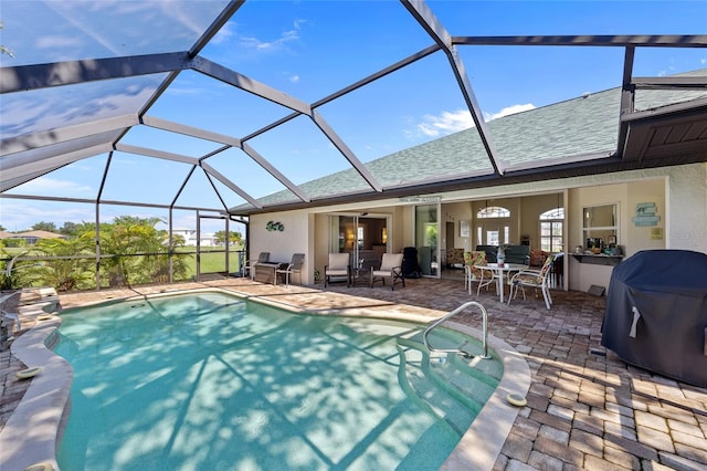 view of swimming pool with a grill, a patio, and a lanai