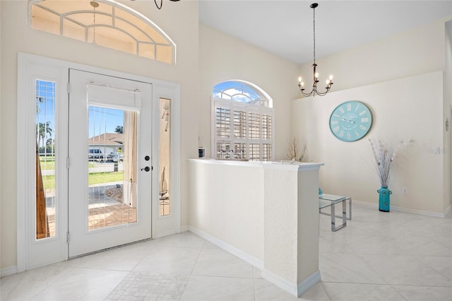 tiled entrance foyer with a wealth of natural light and an inviting chandelier