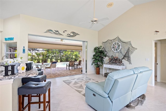 tiled living room featuring ceiling fan and high vaulted ceiling