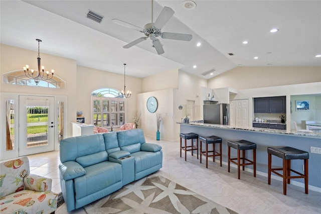 living room featuring ceiling fan with notable chandelier, high vaulted ceiling, and light tile patterned floors