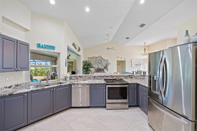 kitchen featuring stainless steel appliances, light stone countertops, sink, and gray cabinetry