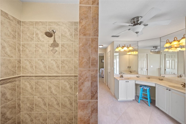 bathroom featuring ceiling fan, vanity, tile patterned floors, and tiled shower